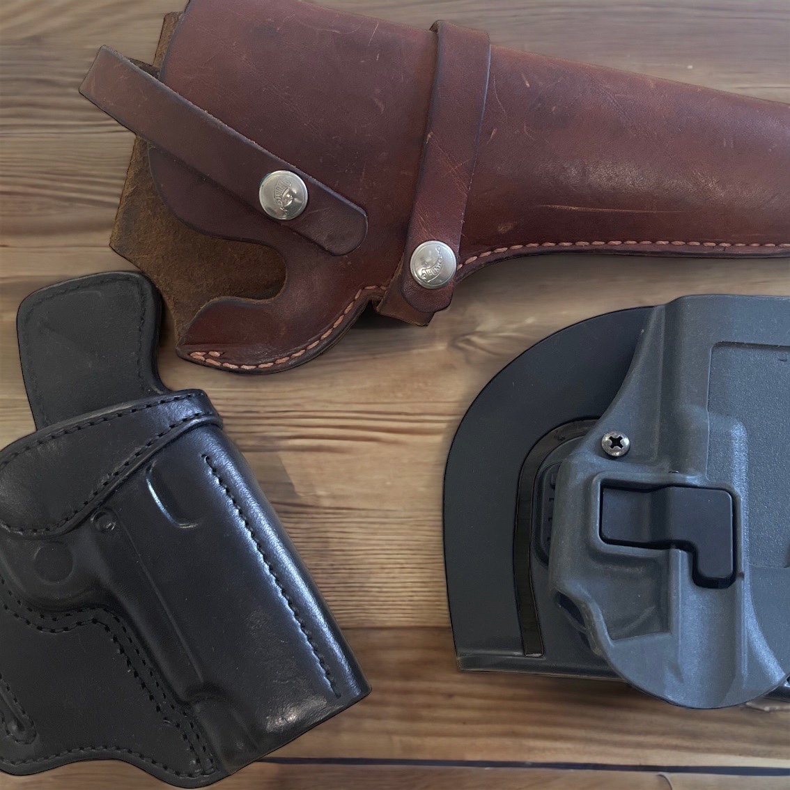 Leather holster and a kydex holster on a table for view